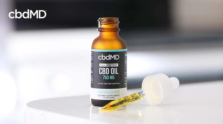 cbdMD Full spectrum tincture on table with dropper out