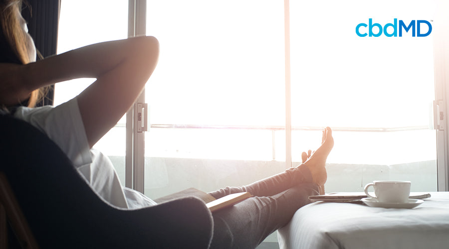 woman relaxing in hotel room with feet up