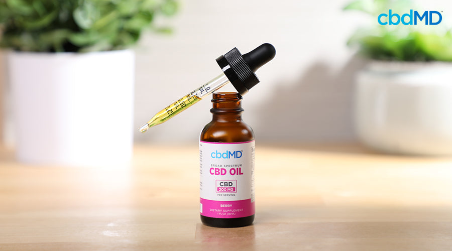 Broad spectrum cbd oil 200 mg cbd per serving berry with a dropper full of cbd oil resting on top - cbdMD