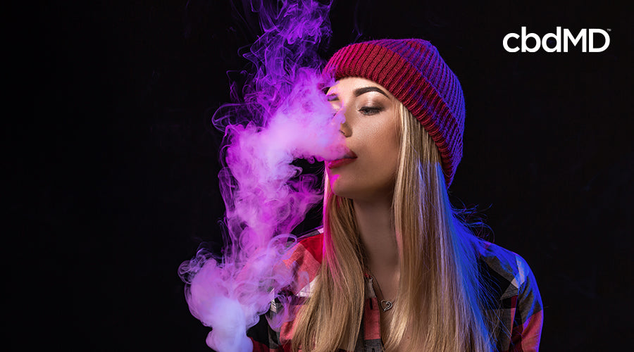 A woman vaping and blowing vaper out of her mouth