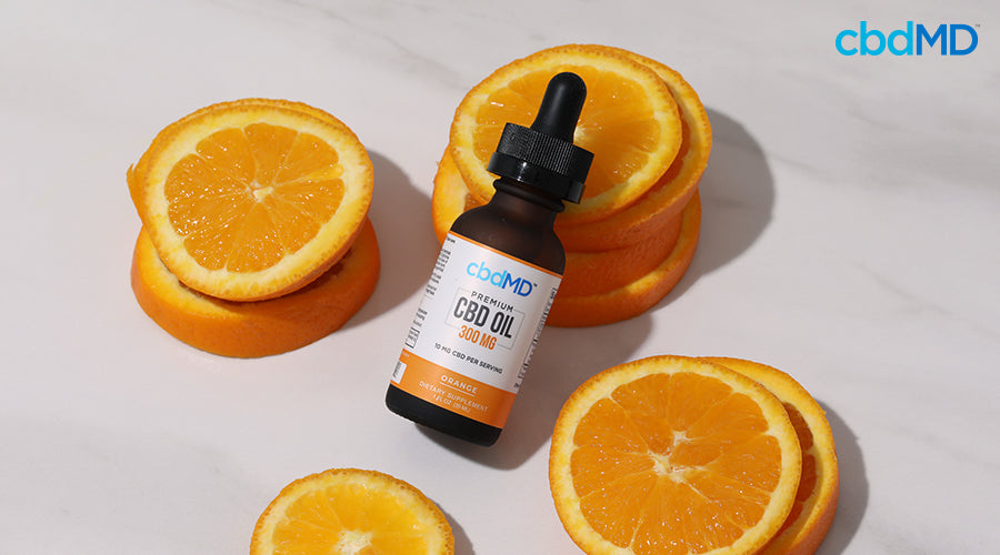 Premium cbd oil 300 mg orange with orange slices around it - cbdMD