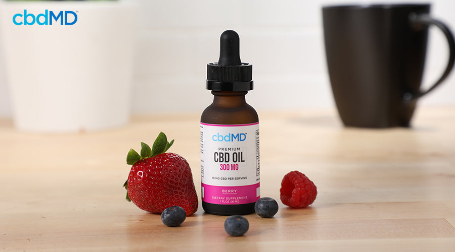 Premium cbd oil 300 mg berry with a mug in the background - cbdMD