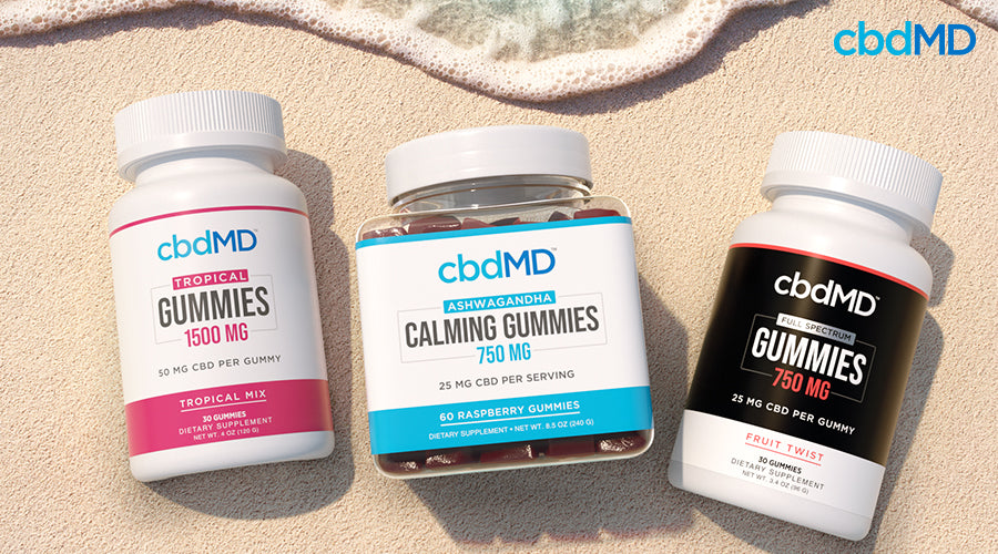 Tropical gummies 1500 mg ashwagandha calming gummies 750 mg raspberry and full spectrum gummies 750 mg fruit twist next to each other on a beach - cbdMD