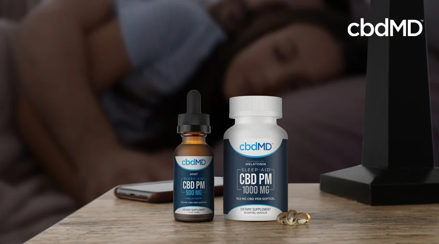 A 500 mg bottle of cbd pm tincture sits next to a bottle of 1000 mg cbd pm capsules