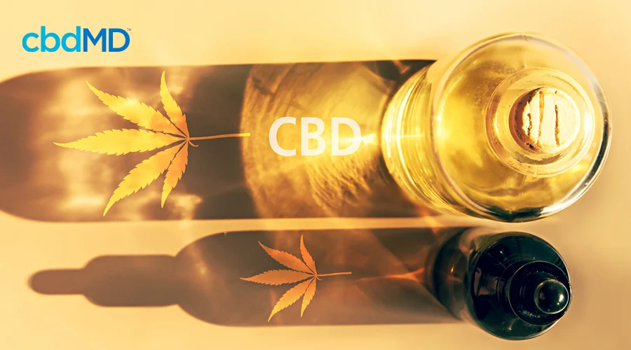 Two glass bottles of cbd oil with the sun shining through it