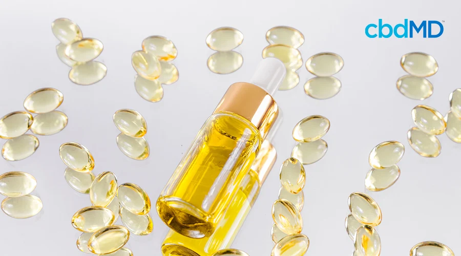 A vial of cbd oil sits among cbd capsules