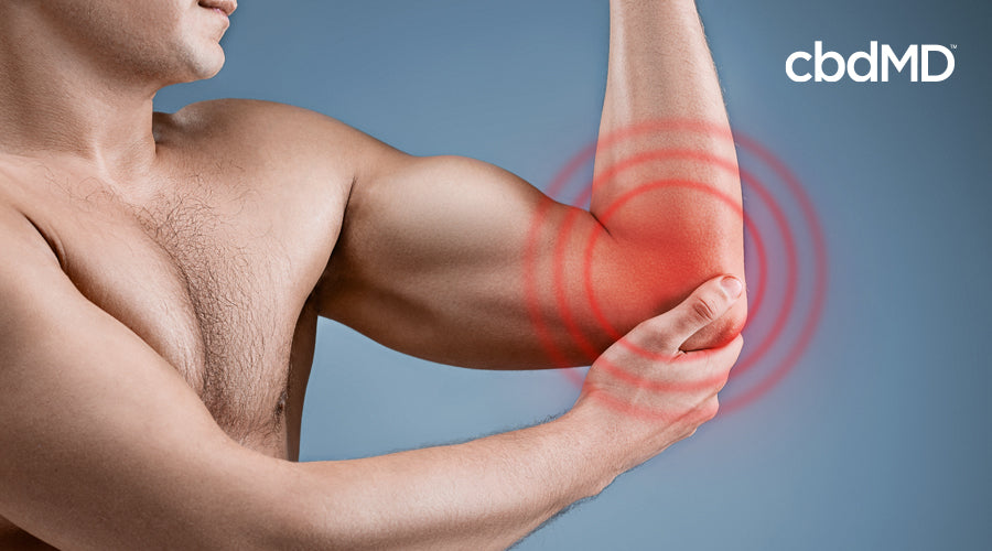 A man holds his elbow with red circles radiating from it to indicate pain
