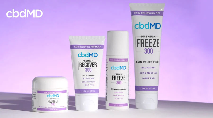 A variety of cbd topical products from cbdmd sits on a table against a purple background