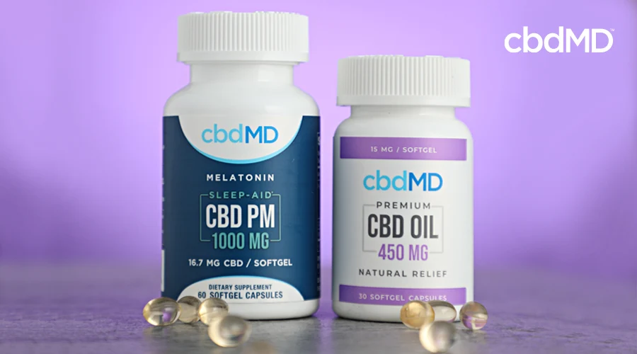 A bottle of 1000 mg cbd pm and 450 mg cbd softgel capsules sit next to one another