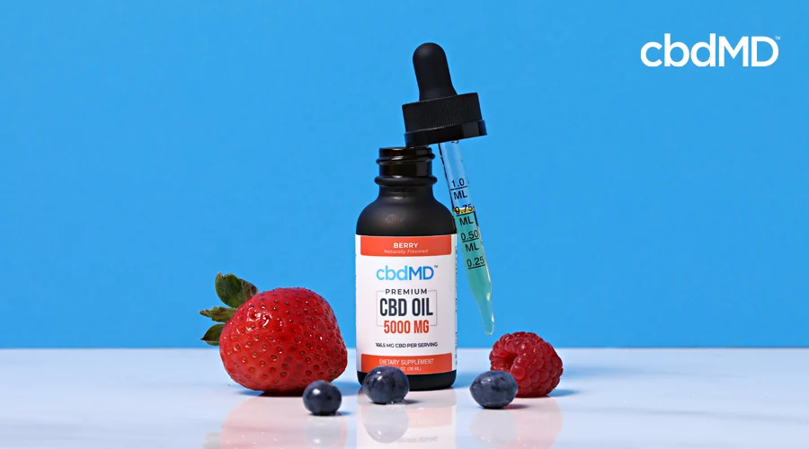A bottle of 5000 mg cbd oil tincture from cbdmd sits next to some fruit