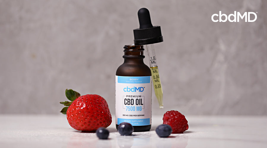 A bottle of 7500 mg berry flavored cbd oil tincture from cbdmd sits near some fruit