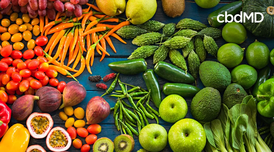 A large assortment of skin power foods sits together including multiple vegetables and fruits