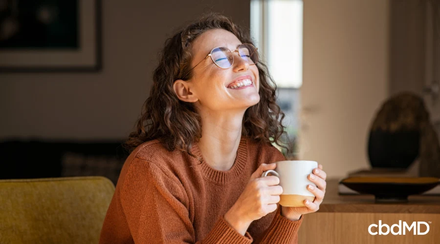 Happy Woman Drinking Evening Tea with CBD Tincture