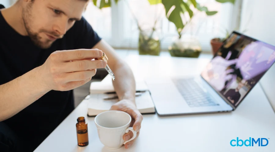 Man Adding CBD Tincture to Daily Coffee