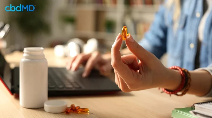 Person Taking CBD Pain Relief Capsules
