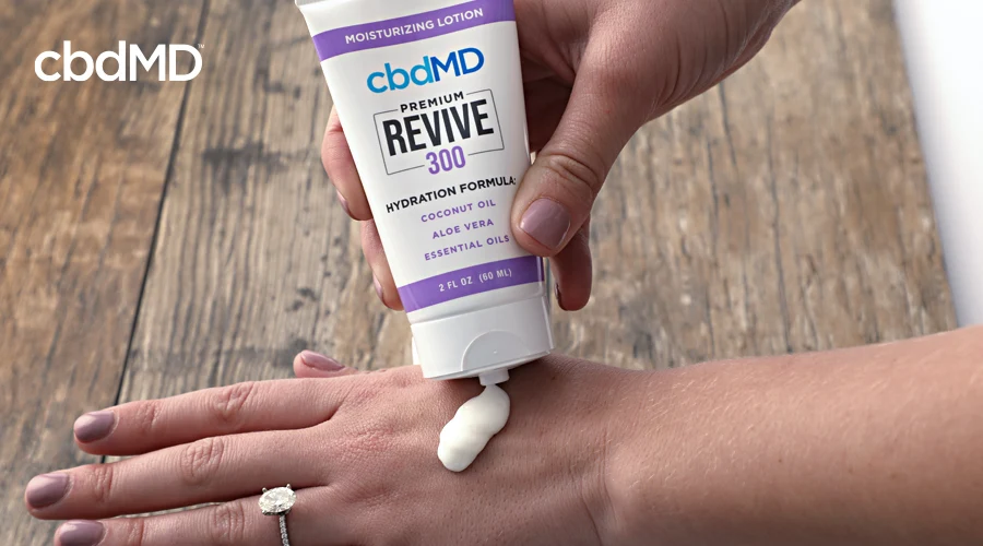A woman squeezes cbd revive from cbdmd onto her hand
