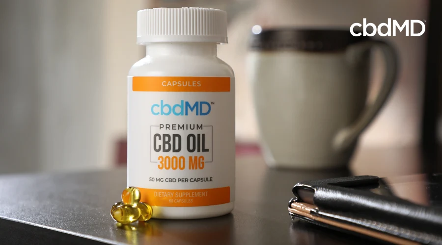 A bottle of 3000 mg cbd oil capsules sits on a night stand