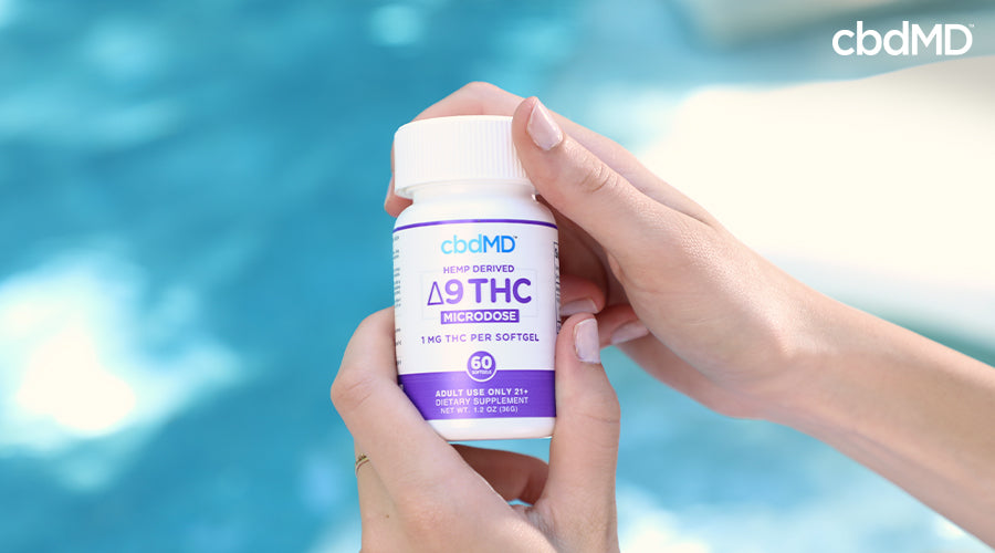 A woman holding delta 9 thc microdose 1 mg capsules in her hands - cbdMD