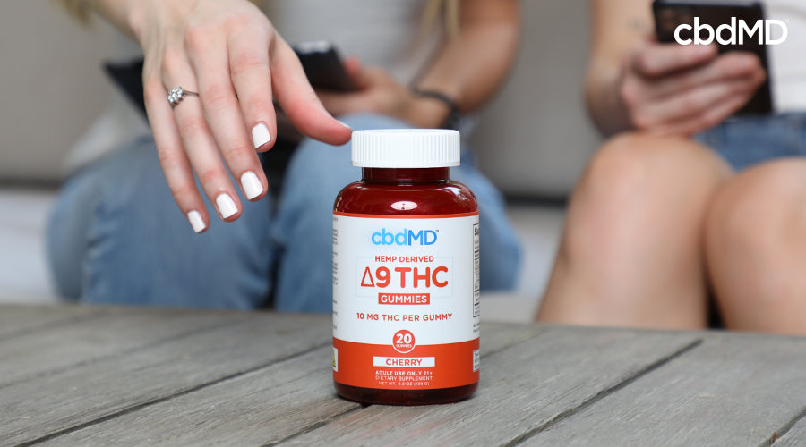 Hemp derived delta 9 thc 10 mg cherry with someone reaching for it - cbdMD