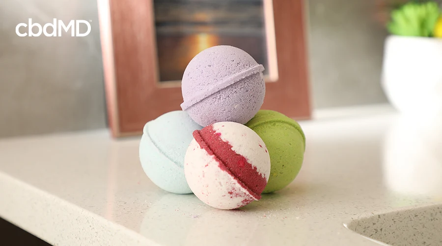A stack of cbd bath bombs from cbdmd sit on a counter