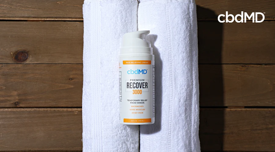A pump tube of 3000 mg cbd recover from cbdmd sits atop rolled towels