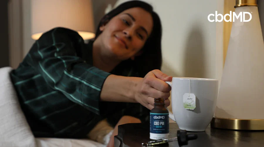 Woman with cup of tea at bedtime with CBD PM tincture