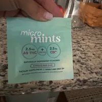 Customer-uploaded image. Click to see more details. The image represents: A hand holding a light blue package of micro mints dietary supplement containing 2.5mg delta-9 THC and 2.5mg CBG per mint, naturally peppermint flavored, marked for adult use only 21+.