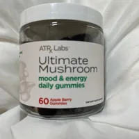 Customer-uploaded image. Click to see more details. The image represents: A bottle of ATR Labs Ultimate Mushroom mood and energy daily gummies containing 60 apple berry flavored gummies, displayed on a white fabric background.