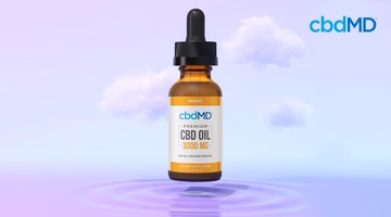 CBD oil tincture bottle with dropper, 3000 mg, floating above rippling water against a purple cloud background.