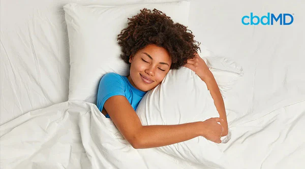 Woman sleeping peacefully in bed, hugging pillow, promoting healthy sleep support