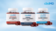 Jars of apple cider vinegar, sleep-aid, and calming CBD gummies against a blue background.