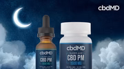 CBD PM sleep aid tincture and softgel bottle against a night sky with moon and clouds