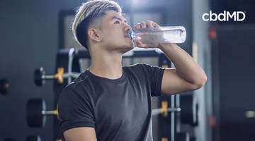 Man drinking water after workout in gym, promoting healthy post-exercise recovery