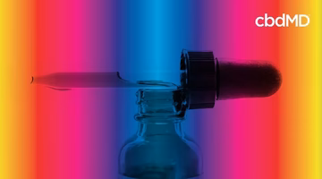 CBD oil dropper and bottle against vibrant full spectrum background
