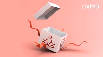 Gift box with red ribbon and yoga icon on pink background, wellness holiday gift concept