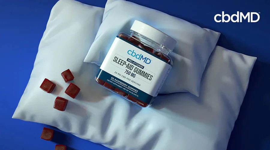Jar of sleep aid gummies with melatonin on a pillow, raspberry flavor, CBD supplement.