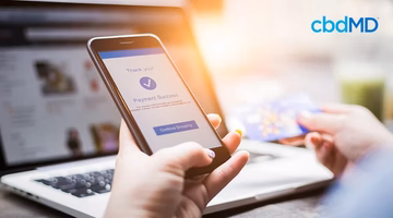 Person completing secure online CBD purchase with smartphone and credit card