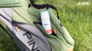 CBD recovery cream in green golf bag pocket on grass, outdoor sports wellness support