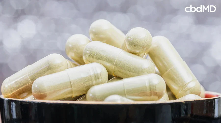 Close-up of CBD capsules in a bowl with blurred background