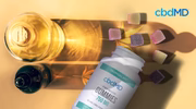 CBD oil bottle and CBD gummies with hemp leaves on a yellow background