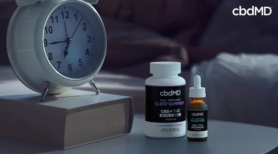 CBD sleep gummies and oil on a bedside table with alarm clock and book, promoting sleep support