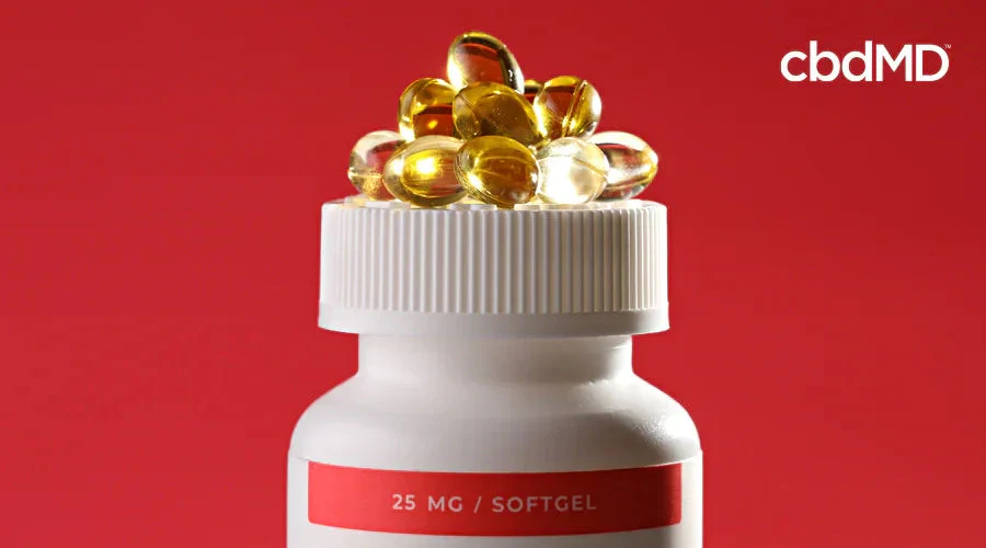 25 mg softgel capsules on bottle lid against red background, cbd softgels supplement