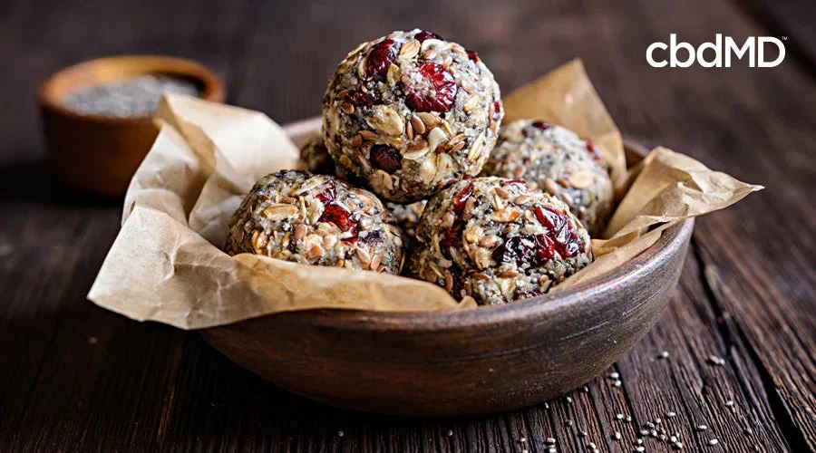 Oatmeal bites with dried berries and seeds in a wooden bowl on rustic table