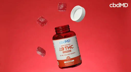 Delta 9 THC gummies bottle with gummies and cap on red background