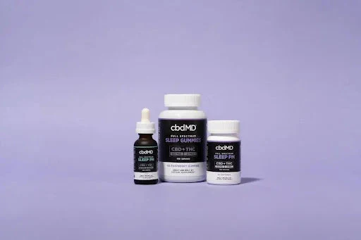 CBD sleep gummies, oil dropper, and capsules on a purple background