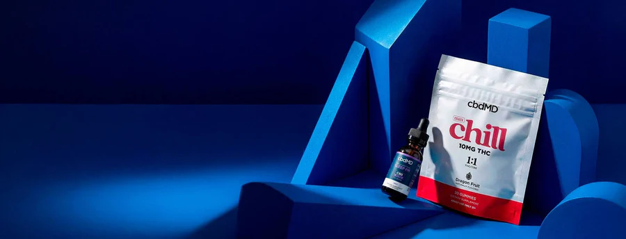 cbdMD chill gummies and tincture on a blue background product display