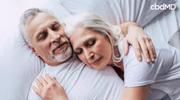 Happy older couple resting in bed, embracing and enjoying peaceful sleep
