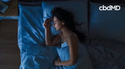 Woman peacefully sleeping in bed at night, promoting natural sleep support