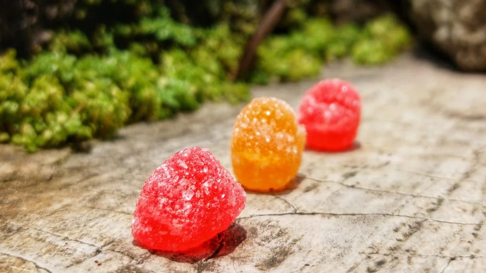 close up view of three jelly candies against stone wall background