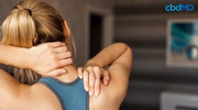 Woman holding neck and shoulder, showing muscle discomfort and need for pain relief